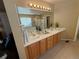 Bathroom featuring double sinks, quartz countertops, framed mirror and vanity lighting at 6044 S Yakima St, Aurora, CO 80015