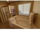 Bright bathroom featuring a bathtub with tile surround, glass shower, and large window at 6044 S Yakima St, Aurora, CO 80015