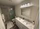 Beautifully renovated bathroom with dual sinks, modern fixtures, and a marble tile shower at 6044 S Yakima St, Aurora, CO 80015