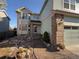 Inviting front entrance with walkway, rock landscaping, and brick accents leading to the front door and attached garage at 6044 S Yakima St, Aurora, CO 80015