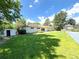 Large backyard with lush green grass, mature trees, storage shed and a private tennis court at 9451 E Evans Pl, Denver, CO 80231