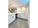 Basement bar featuring white cabinets, stone countertop, wine fridge, and modern pendant lighting at 9451 E Evans Pl, Denver, CO 80231