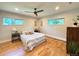 Spacious bedroom with hardwood floors, a ceiling fan, and large windows providing natural light at 9451 E Evans Pl, Denver, CO 80231