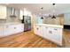 Gourmet kitchen with modern white cabinetry, stainless appliances, and open layout at 9451 E Evans Pl, Denver, CO 80231