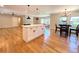 Open concept kitchen featuring a central island, stainless appliances, and an adjacent dining area at 9451 E Evans Pl, Denver, CO 80231