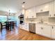 Renovated eat-in kitchen featuring stainless appliances, modern light fixtures, and new cabinetry at 9451 E Evans Pl, Denver, CO 80231