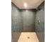 Walk-in shower showcasing dark honeycomb tiling and a dual shower head for a spa-like experience at 9451 E Evans Pl, Denver, CO 80231