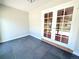 Light-filled sunroom with French doors, brick accent wall, and gray tiled floor, ideal for relaxation at 9451 E Evans Pl, Denver, CO 80231