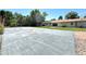 View of the well-kept tennis court in the backyard of this home, featuring a grass border and privacy fence at 9451 E Evans Pl, Denver, CO 80231