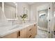 Bright bathroom featuring a double sink vanity, modern mirrors, and a glass-enclosed shower at 2330 Eliot St # 1, Denver, CO 80211