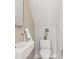 Charming powder room with a compact sink, modern toilet, and light beige tiled wall at 2330 Eliot St # 1, Denver, CO 80211