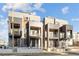 Modern townhomes with recessed balconies and sleek architectural details under a bright sky at 2330 Eliot St # 1, Denver, CO 80211