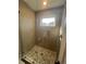 Walk-in shower with glass door, tiled walls, and mosaic tile flooring at 2330 Eliot St # 1, Denver, CO 80211