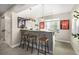 Finished basement wet bar area featuring pendant lighting, football decor, and seating for entertaining guests at 2190 S Poppy St, Lakewood, CO 80228