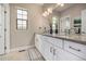 Elegant bathroom with double sinks, sleek white cabinetry, a large mirror, and modern fixtures at 2190 S Poppy St, Lakewood, CO 80228