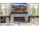 Close-up view of the modern fireplace with stone surround, mantle decor, and built-in storage cabinets at 2190 S Poppy St, Lakewood, CO 80228