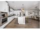 Modern kitchen with white cabinets, stainless steel appliances, a center island, and seamless transition to the dining area at 2190 S Poppy St, Lakewood, CO 80228