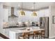 Well-equipped kitchen with marble backsplash, stainless steel appliances, and pendant lights over a large kitchen island at 2190 S Poppy St, Lakewood, CO 80228