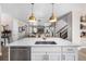 Stylish kitchen featuring a large island with counter seating, pendant lighting, and an open view to the living space at 2190 S Poppy St, Lakewood, CO 80228