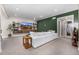 Spacious living room with a large white sofa, green accent wall, and a mounted TV for entertaining at 2190 S Poppy St, Lakewood, CO 80228