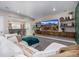 Open-concept living room with a bar area, a white sofa, and a mounted TV for seamless entertainment at 2190 S Poppy St, Lakewood, CO 80228