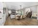 Open concept living room with hardwood floors, a cozy fireplace, and seamless flow to the dining area and staircase at 2190 S Poppy St, Lakewood, CO 80228