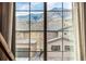A view of neighboring homes through a multi-paned window with mountain in background at 2190 S Poppy St, Lakewood, CO 80228