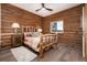 Inviting bedroom with log-paneled walls and a rustic wooden bed frame at 57 Overlook Ct, Idaho Springs, CO 80452