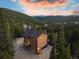 Stunning exterior of the mountain home nestled in a forest with a charming deck and welcoming front porch at 57 Overlook Ct, Idaho Springs, CO 80452