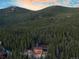 Exterior shot of a log cabin home surrounded by dense forest in mountainous area at 57 Overlook Ct, Idaho Springs, CO 80452