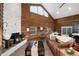 An inviting open-concept living space featuring a stone fireplace, wood walls, and large windows showcasing mountain views at 57 Overlook Ct, Idaho Springs, CO 80452