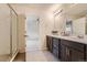 Bathroom featuring double sinks with modern fixtures, a large mirror, and a glass shower at 10863 Endeavor Dr, Parker, CO 80134