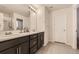 Bathroom featuring double sinks with modern fixtures, a large mirror, and a walk-in shower at 10863 Endeavor Dr, Parker, CO 80134