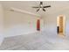 Large bedroom space with neutral carpet, ceiling fan and doors to a bathroom and closet at 10863 Endeavor Dr, Parker, CO 80134