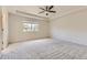 Spacious bedroom featuring neutral carpet, a ceiling fan, and natural light from the window at 10863 Endeavor Dr, Parker, CO 80134
