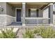 Inviting front porch with stylish pillars, a window, stone accents and well-maintained landscaping at 10863 Endeavor Dr, Parker, CO 80134