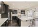 Spacious kitchen with a large island, dark cabinets, stainless steel appliances, and mosaic backsplash at 10863 Endeavor Dr, Parker, CO 80134