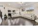 Open-concept living area with hardwood floors, modern lighting, and a view of the adjacent kitchen at 10863 Endeavor Dr, Parker, CO 80134