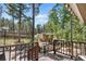 Wooden deck with views of the property's shed roof, trees, and natural beauty of the surroundings at 26196 Rea Ave, Conifer, CO 80433