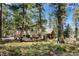 Picturesque home with a large outdoor area, benches, and a lush, natural tree surround at 26196 Rea Ave, Conifer, CO 80433