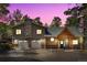 Charming two-story home features a stone chimney, a front porch with a wooden structure, and a well-maintained yard at 26196 Rea Ave, Conifer, CO 80433