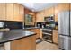 Well-appointed kitchen featuring stainless steel appliances, dark countertops, and natural wood cabinets at 26196 Rea Ave, Conifer, CO 80433