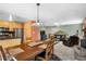 Open-concept dining room leading to a living area with a cozy fireplace and kitchen space at 26196 Rea Ave, Conifer, CO 80433