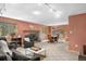 Spacious living room featuring a stone fireplace, wood trim windows, and outdoor views at 26196 Rea Ave, Conifer, CO 80433