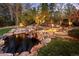 The backyard is illuminated by elegant string lights and a soothing waterfall feature for a serene and private outdoor space at 6402 E Cornell Ave, Denver, CO 80222