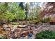 Extensive backyard features a picturesque koi pond, a cozy fire pit, and lush landscaping at 6402 E Cornell Ave, Denver, CO 80222