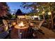 A stone fire pit and surrounding seats create the perfect setting for relaxing conversations under the starlit sky at 6402 E Cornell Ave, Denver, CO 80222