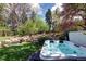 Relax and unwind in the backyard's luxurious hot tub with a scenic view of the lush landscaping and calming waterfall at 6402 E Cornell Ave, Denver, CO 80222