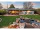 The ultimate outdoor space, a beautiful backyard featuring a stone waterfall, built-in bar, and covered patio at 6402 E Cornell Ave, Denver, CO 80222