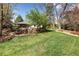 Expansive backyard offers a charming fire pit area surrounded by mature trees and lush greenery at 6402 E Cornell Ave, Denver, CO 80222